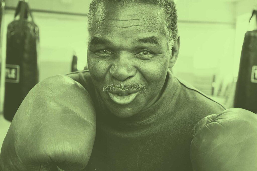 An old boxer with a wry smile as he gets ready to train.