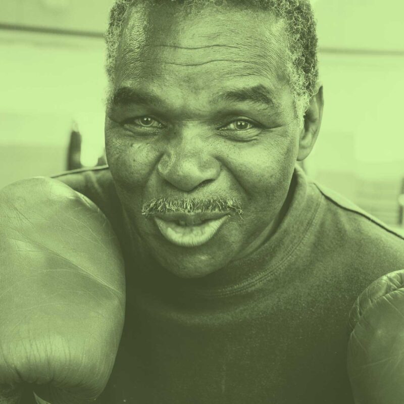 An old boxer with a wry smile as he gets ready to train.